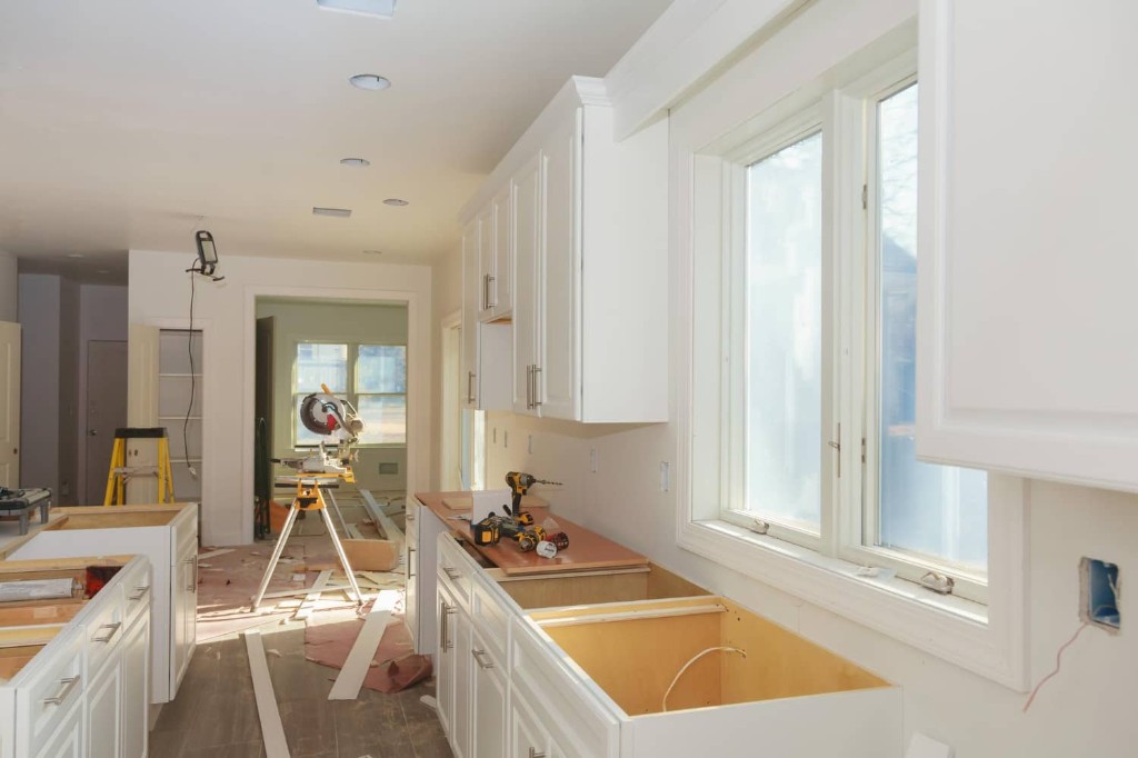 Kitchen remodel in progress with new white cabinetry